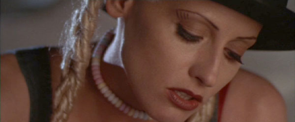 Tank Girl: Rebecca in her suspenders and hat with attached braids.