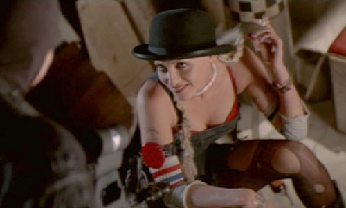 Tank Girl: Surprised by a soldier while on guard duty, Rebecca attempts to distract him with a little striptease.