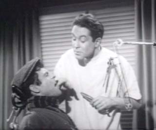 The Little Shop of Horrors (1960): Seymour (Jonathan Haze) in Dr. Phoebus Farb's (John Herman Shaner) chair.