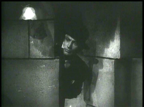 The Devil Bat: Layton sneaks back into the lab to spy on Carruthers.